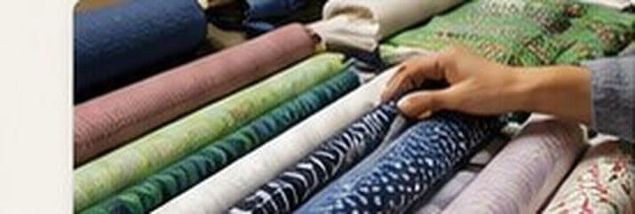 Rolled bolts of colorful fabric on display